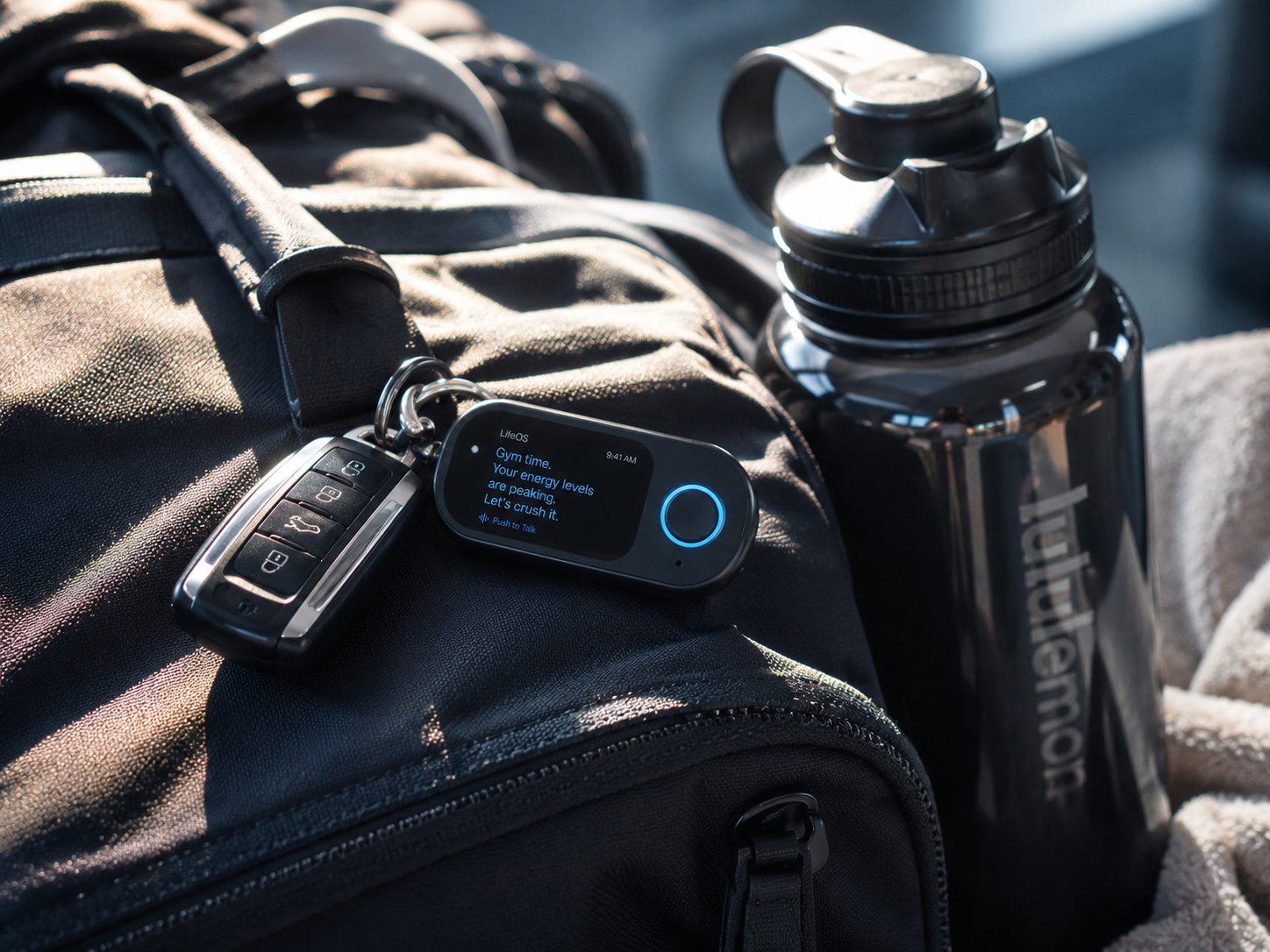 Kyven device clipped to a gym bag showing an energy-level reminder before a workout